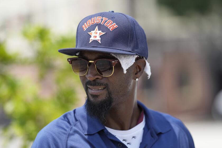 Parking lot attendant Donnay Wright wears a towel under his ball cap as he tries to keep cool in the heat outside Minute Maid Park before a baseball game between the Cincinnati Reds and Houston Astros Saturday, June 17, 2023, in Houston. (AP Photo/David J. Phillip)
