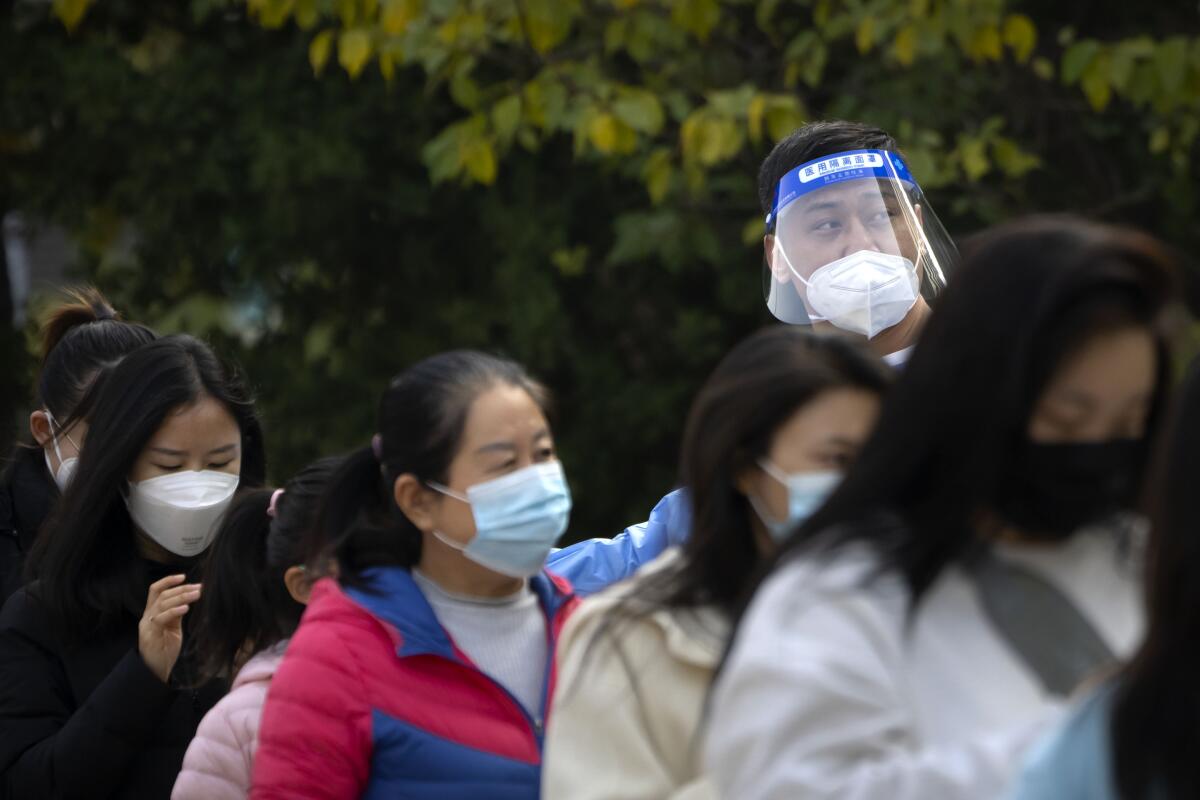Numerosas mujeres hacen fila para hacerse pruebas de COVID-19 en un lugar especial en Beijing, 