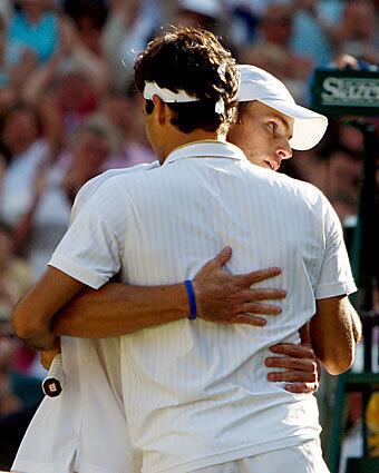 Andy Roddick of the US embraces Roger Federer of Switzerland