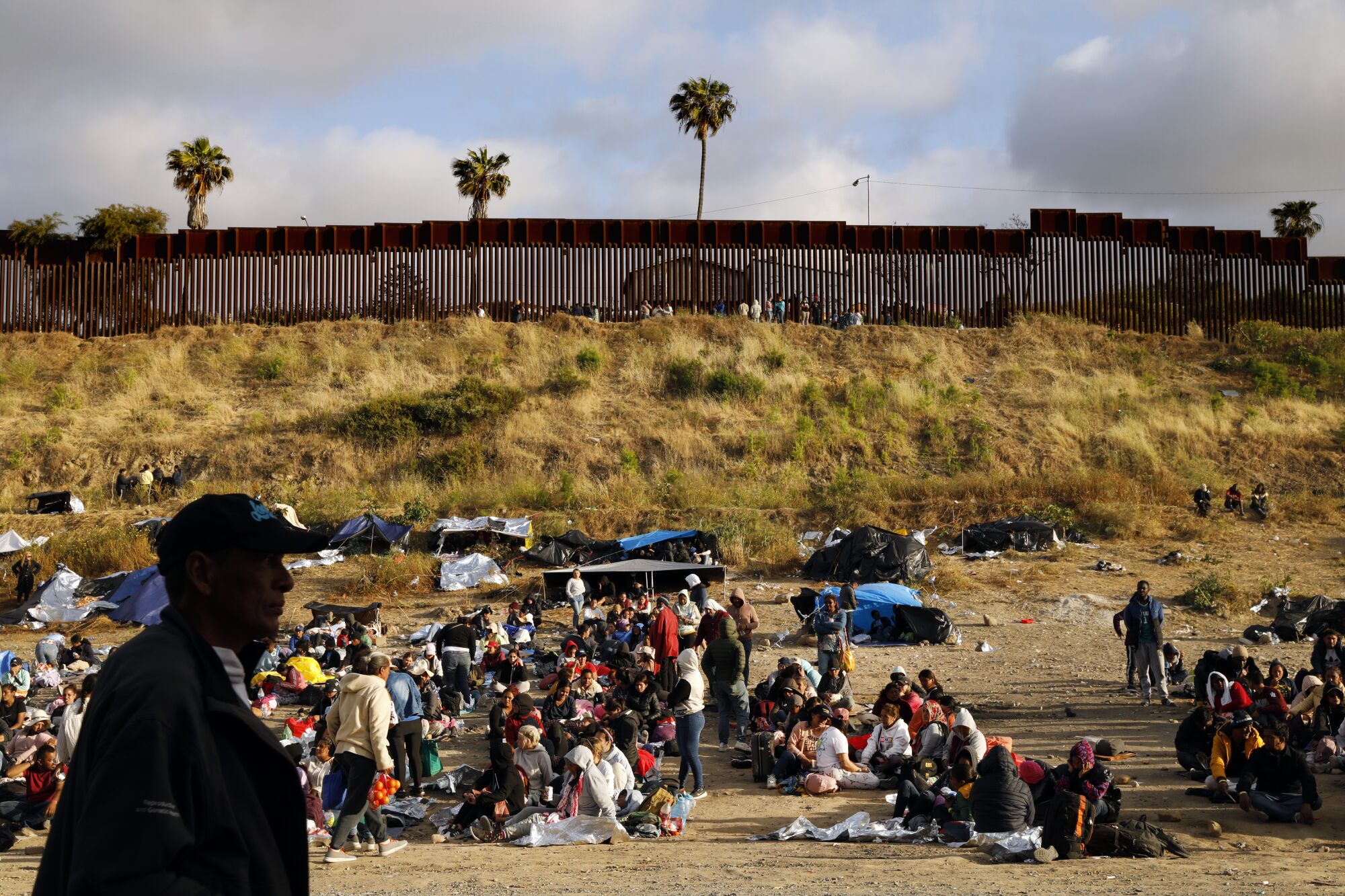 Migrants hoping to cross into the United States from Tijuana try to keep warm on May 12.