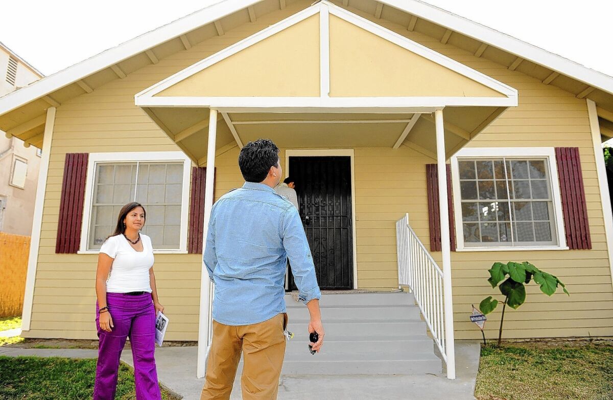 Citlali and Israel Gonzales inspect a house for sale in South Los Angeles. They wanted a home in a new development when they started their search a year ago, but found few choices.
