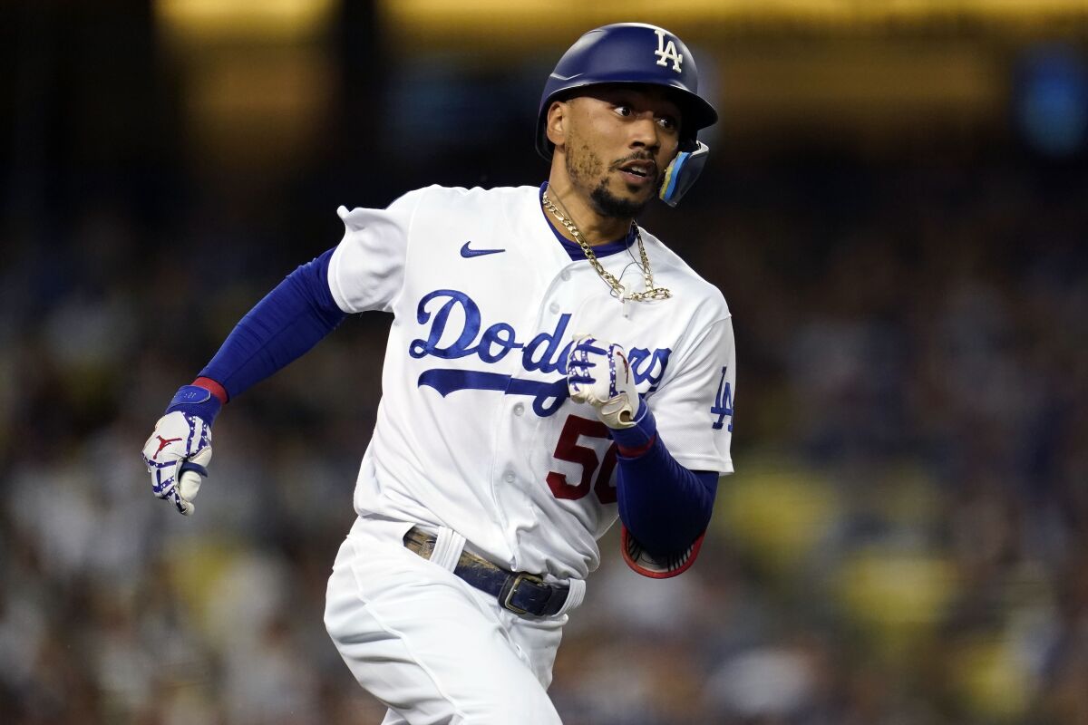 Los Angeles Dodgers' Mookie Betts rounds first base as he doubles during the third inning of a baseball game against the Colorado Rockies Saturday, Oct. 1, 2022, in Los Angeles. (AP Photo/Marcio Jose Sanchez)
