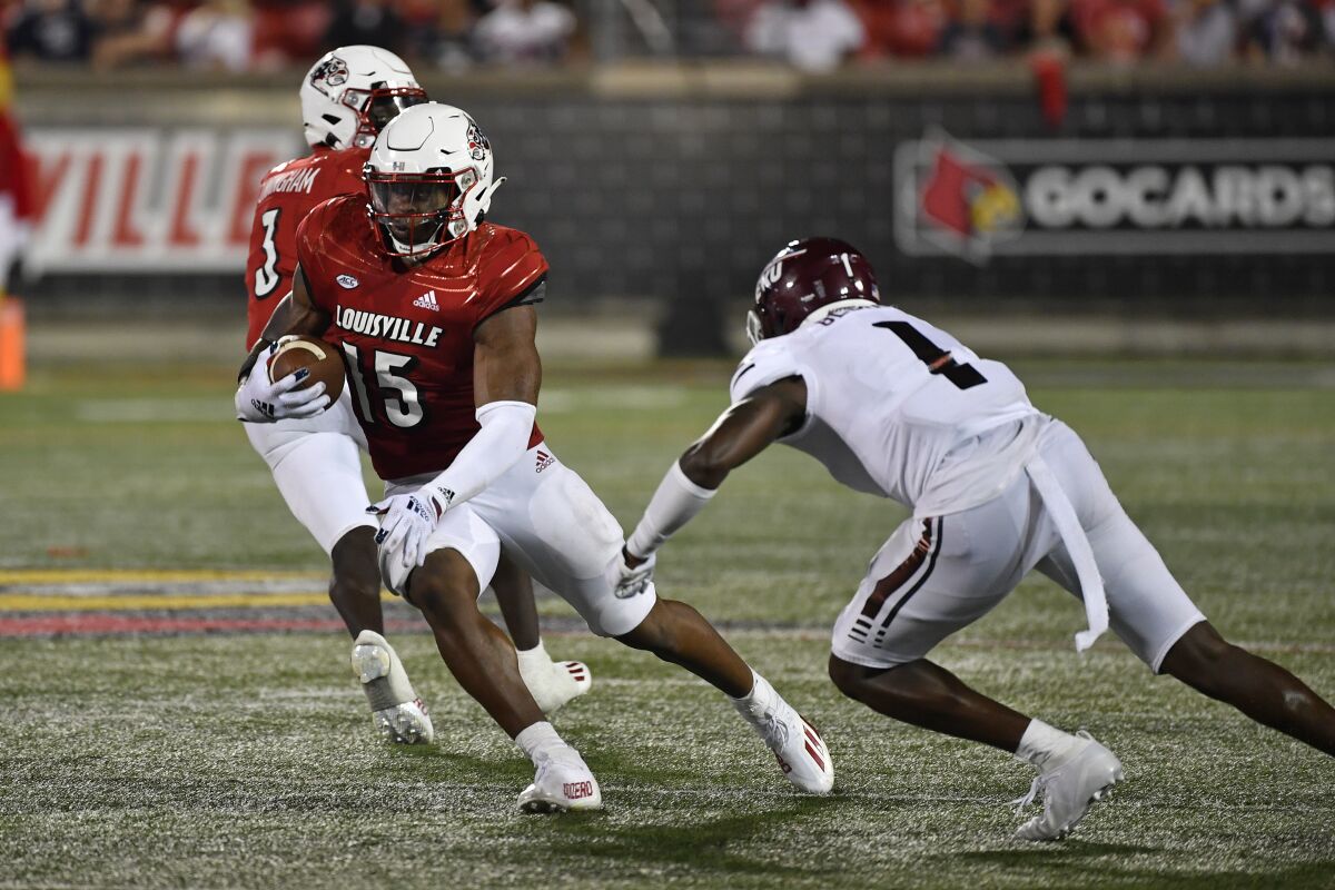 Louisville running back Jalen Mitchell (15) tries to avoid a tackle-attempt by Eastern Kentucky defensive back John Blount Jr. during the second half of an NCAA college football game in Louisville, Ky., Saturday, Sept. 11, 2021. (AP Photo/Timothy D. Easley)