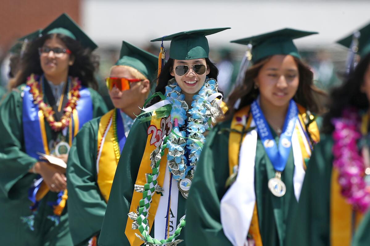 Decorated graduates Thursday walk in a procession at Costa Mesa High School's graduation ceremony.