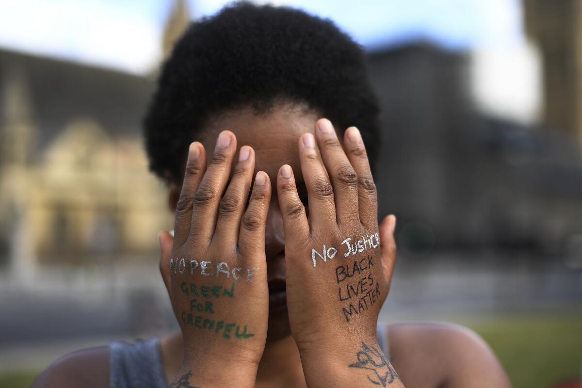 A woman symbolically covers her eyes as she participates in a Black Lives Matter protest 