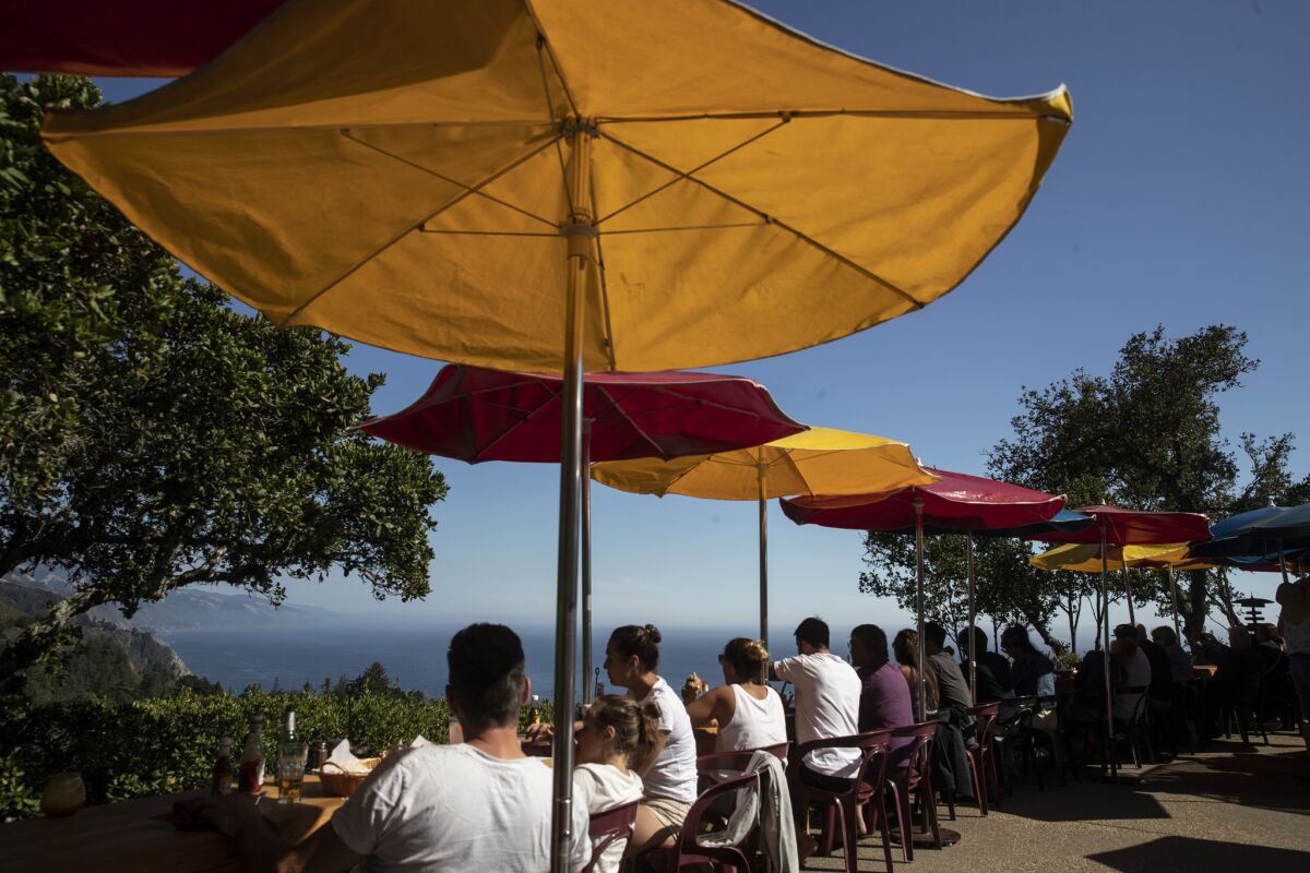 Diners gather on a deck perched on a cliffside at Nepenthe in Big Sur on Aug. 1, 2018.