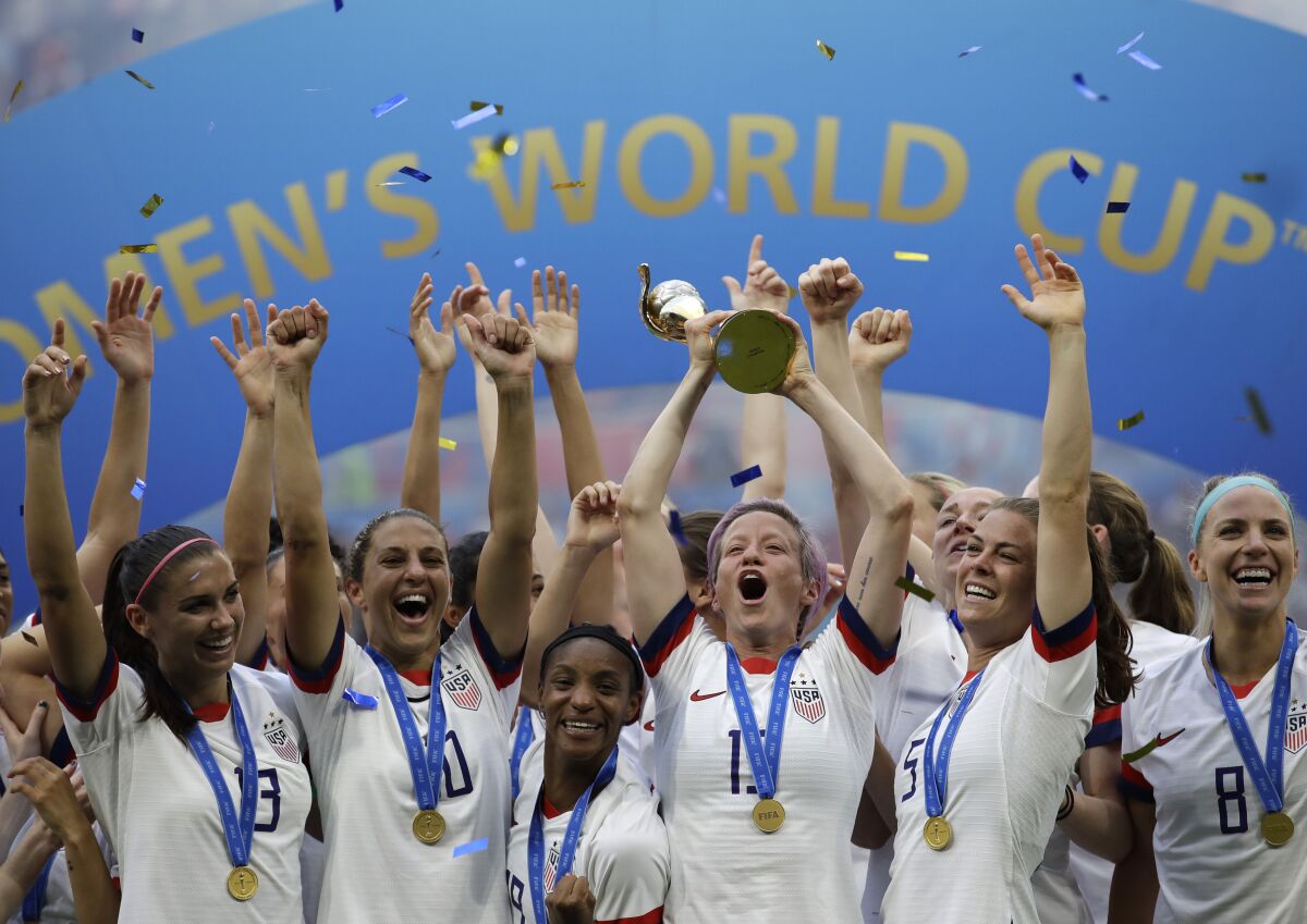 The United States' Megan Rapinoe lifts trophy and celebrates with teammates after winning the 2019 Women's World Cup 