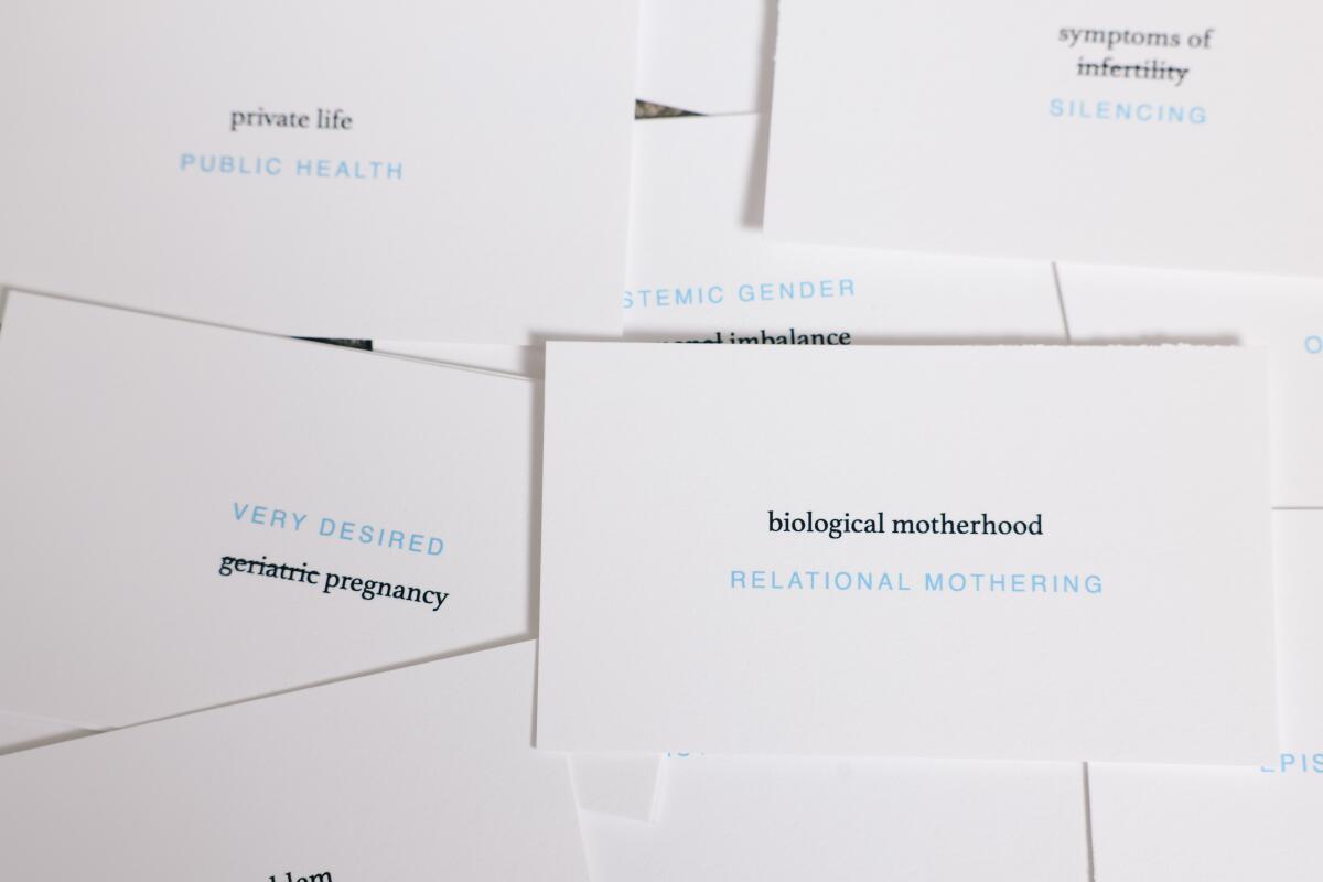 Small cards printed with phrases including "geriatric pregnancy" and "biological motherhood"
