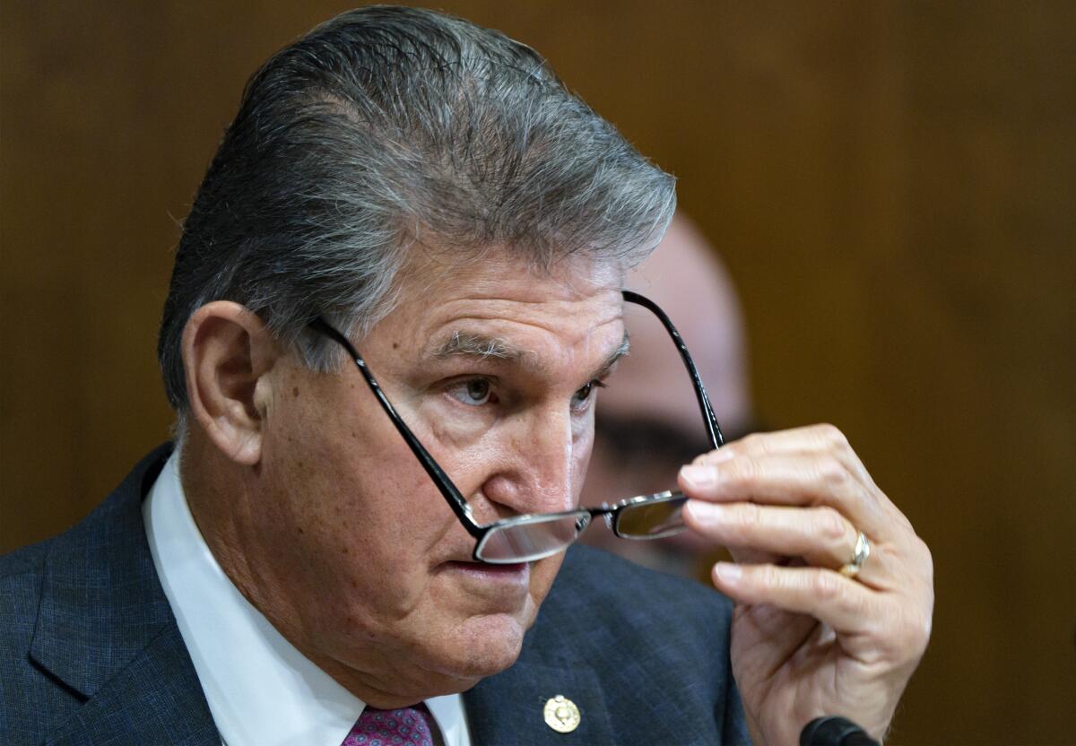 Sen. Joe Manchin III holds a pair of glasses