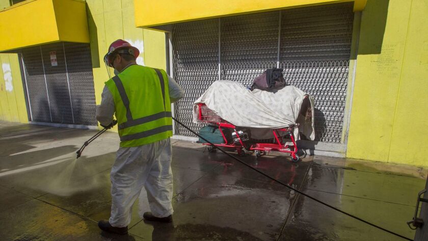 Clean Harbors, a private contractor, power washes sidewalks in downtown San Diego with a bleach solution in an attempt to stop the spread of hepatitis A.