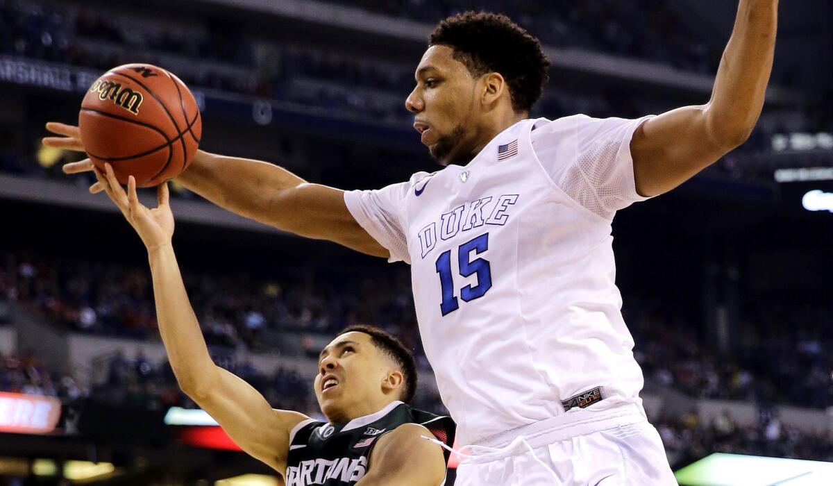 Duke center Jahlil Okafor tries to block a shot by Michigan State guard Travis Trice last week.