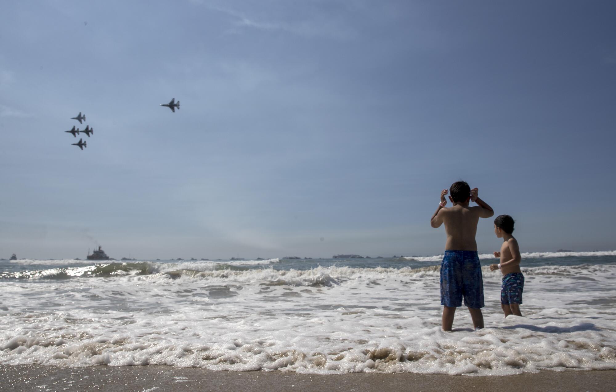 Ari Anival, 8, left, covers his ears as he and brother Uri, 7, right, watch the U.S. Air Force Thunderbirds 