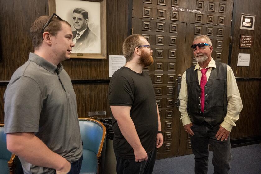Placerville, California-June 28, 2024-Ricky Davis, right, speaks with Connie Dahl's children, Nick Dahl, left and Jarred Lange, center, before entering the El Dorado County Courthouse Friday, June 28, 2024. The 1985 murder case where Connie Dahl (now deceased) and Ricky Davis were accused of murder. DNA tests in the early 2000's allowed for a new trial. Davis was exonerated in February of 2020. (Jose Luis Villegas / For the TImes)