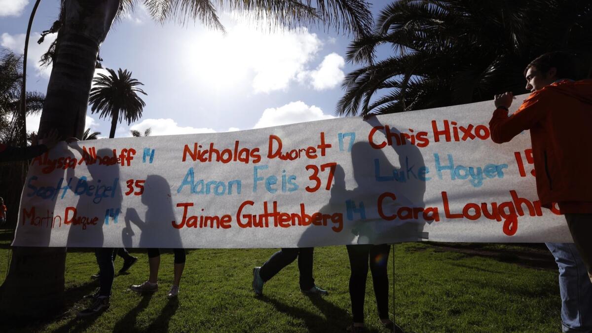 Venice High School students hang a banner with the names of the Stoneman Douglas High School victims during national walkouts in support of gun control and safe schools.