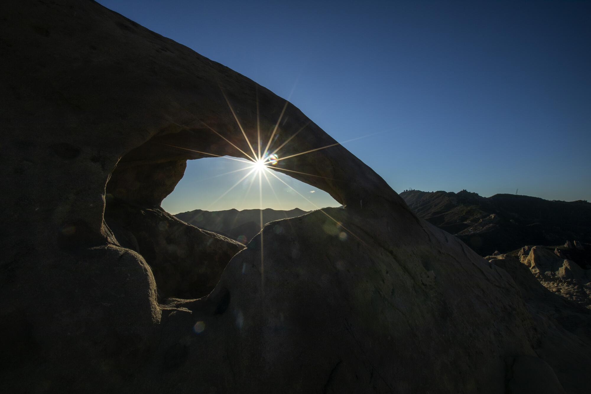 A stone arch frames the sunset in Corral Canyon.