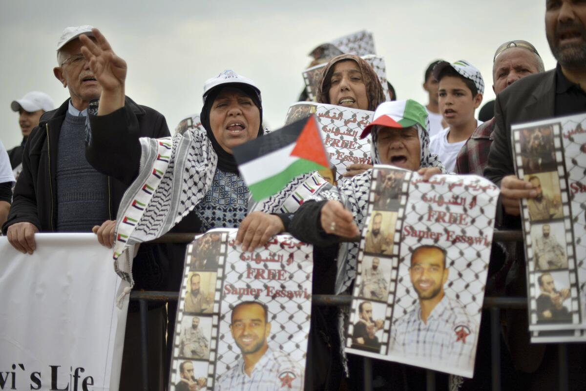 Protesters hold posters showing Palestinian prisoner Samer Issawi outside a hospital in Rehovot, Israel.