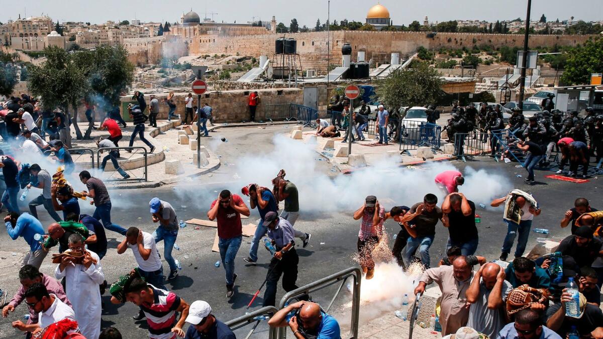 Palestinian worshipers flee tear gas fired by Israeli forces outside Jerusalem's Old City in front of the Al Aqsa Mosque compound on July 21, 2017.