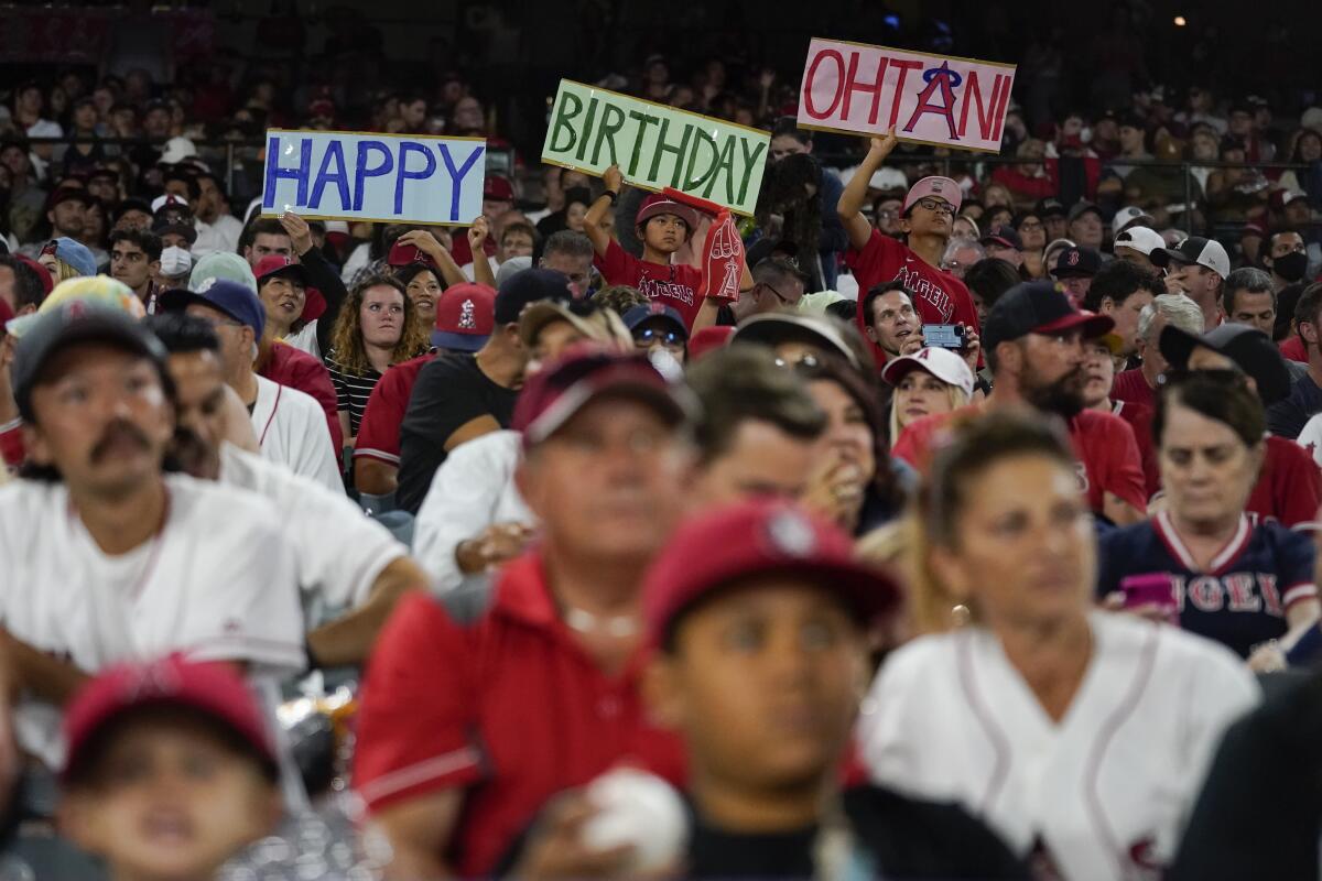 Fans hold up signs recognizing Shohei Ohtani's 27th birthday during Monday's game against the Boston Red Sox.