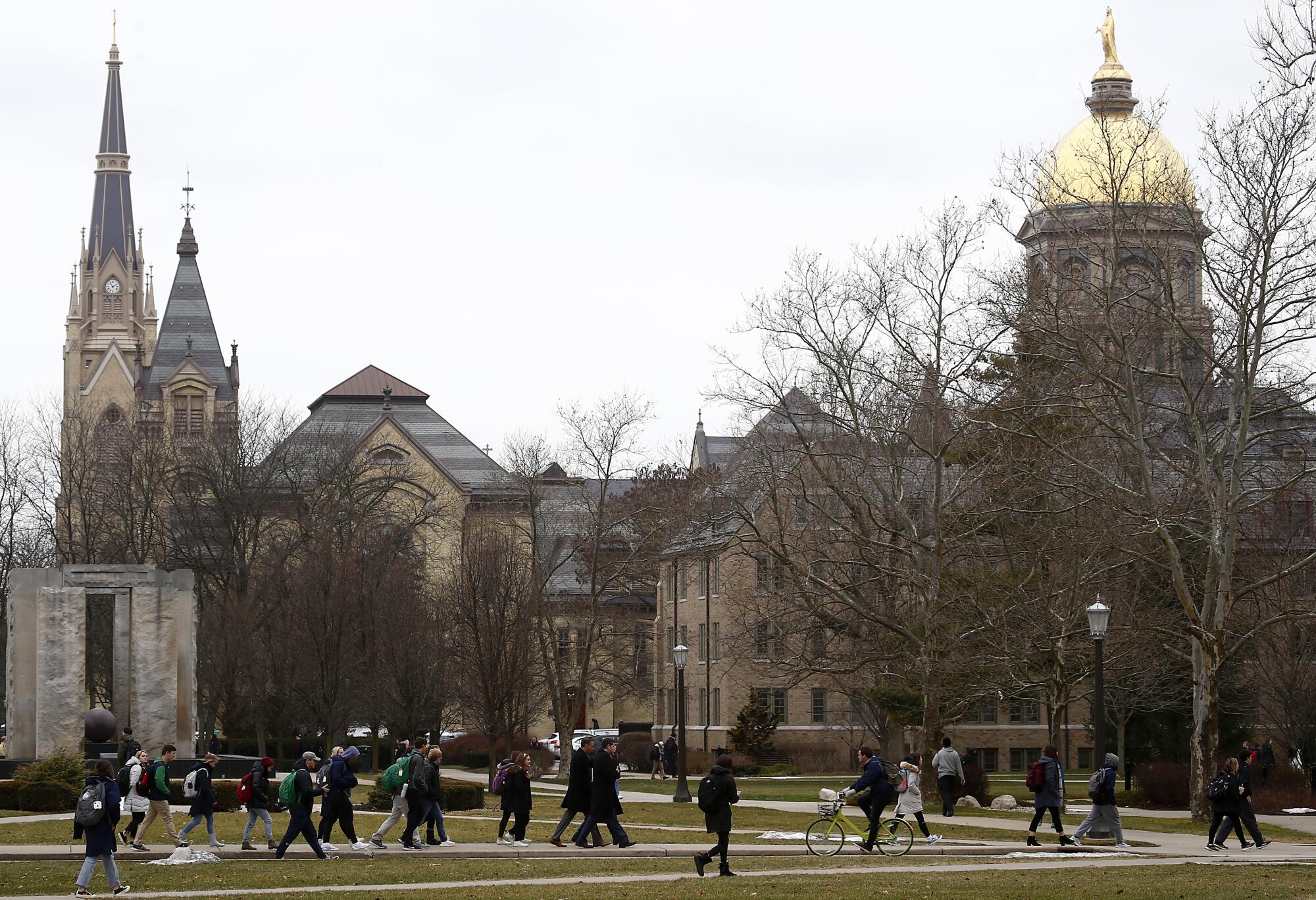 Students walk across the campus of the University of Notre Dame on the outskirts of South Bend, Ind.