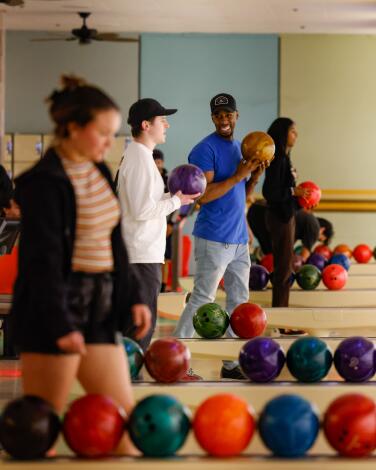 People bowl at a bowling alley.