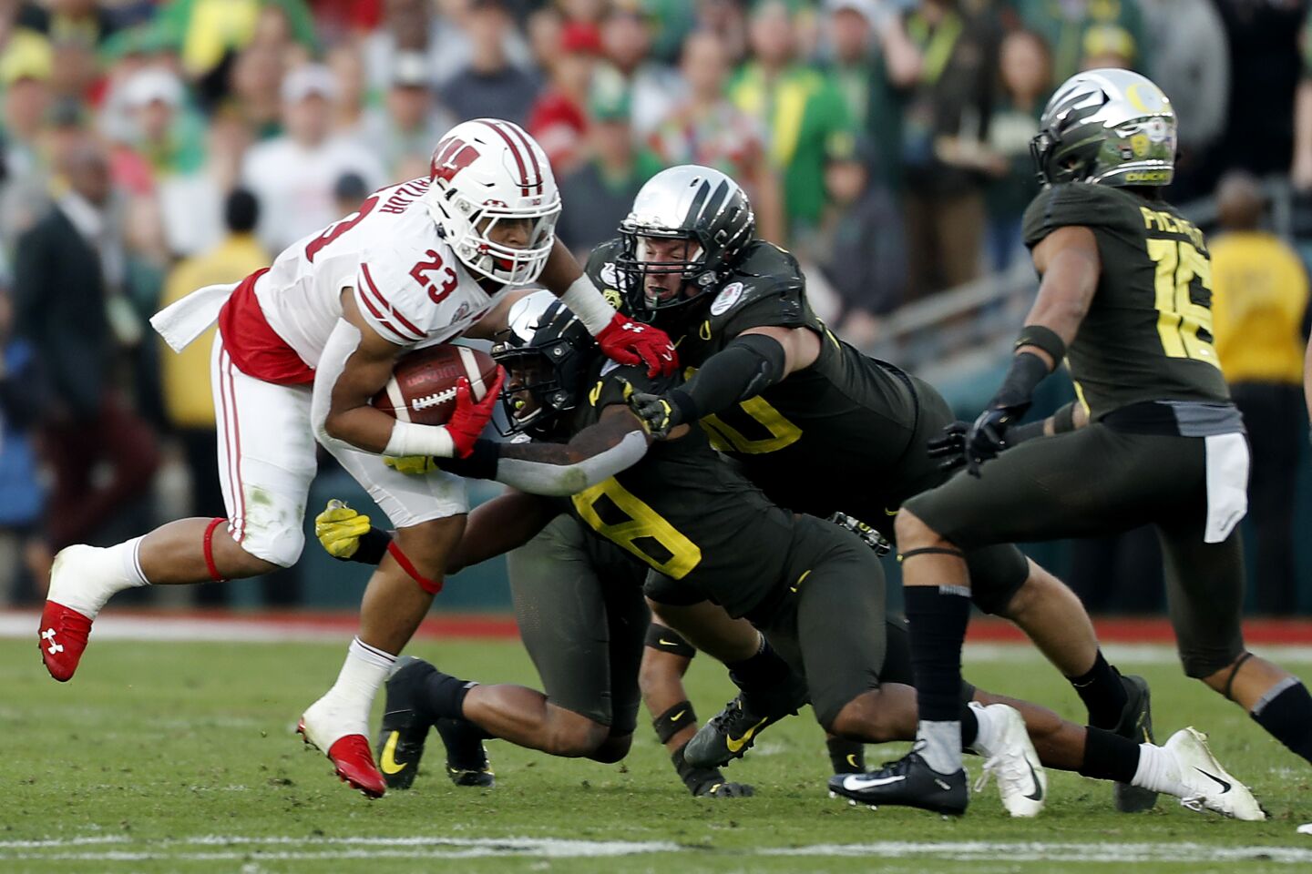 The Oregon defense swarms around Wisconsin running back Jonathan Taylor during the third quarter.