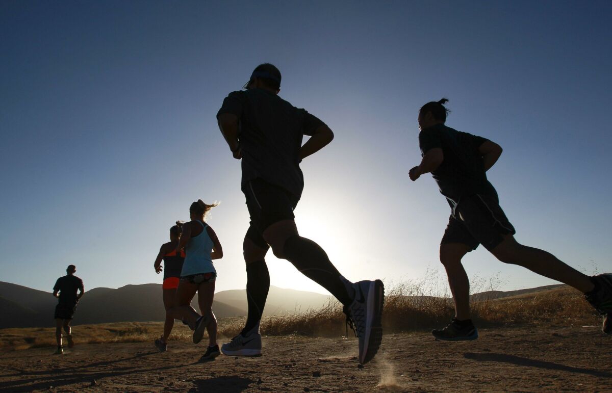 Members of Performance Strength Lab run together as they demonstrate running in hot weather at Mission Trails Regional Park in Santee. Hayne Palmour IV