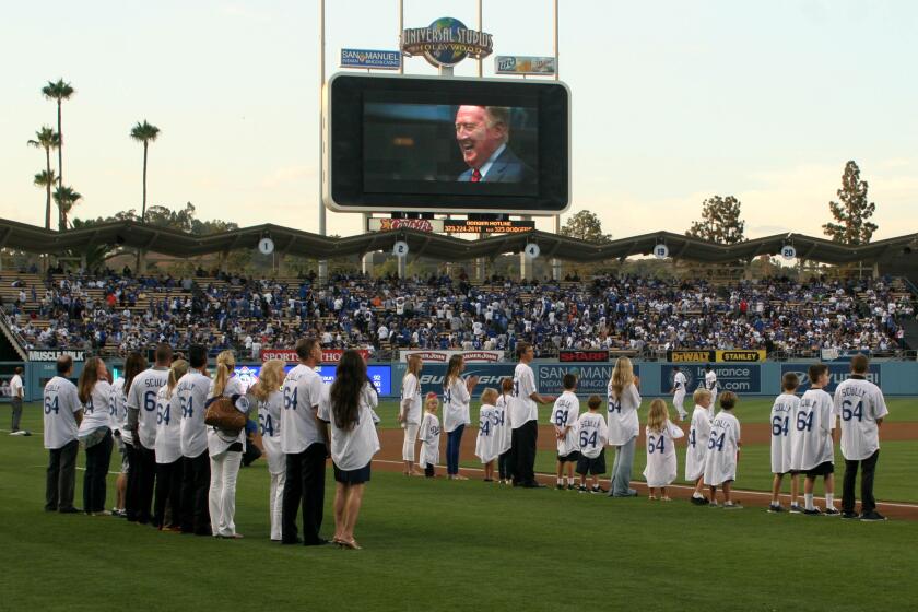 The grandchildren of Vin Scully show their love for Vin Scully on Vin Scully bobblehead night at Dodger Stadium before the game on Thursday August 30, 2012 in Los Angeles (AP Photo/Kevin Reece)