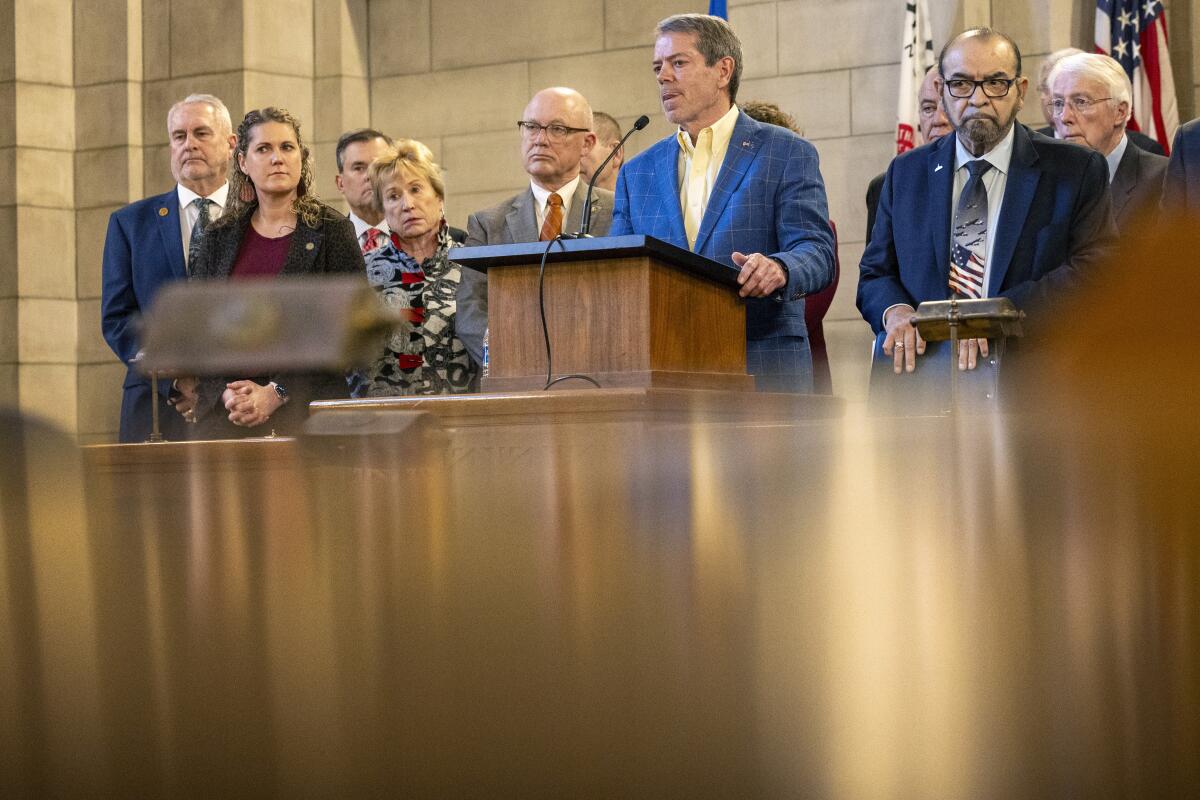 Gov. Jim Pillen is joined by other state senators as he announces that the state will participate in the Summer Electronic Benefits Transfer Program after previously saying Nebraska wouldn't take part during a press conference in the Warner Chamber at the Capitol, Monday, Feb. 12, 2024, in Lincoln, Neb. (Kenneth Ferriera/Lincoln Journal Star via AP)