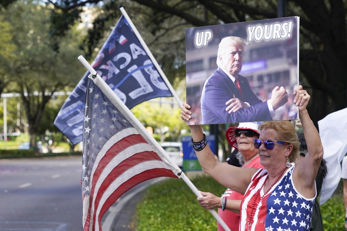 Seguidores de Donald Trump ondean banderas y letreros 