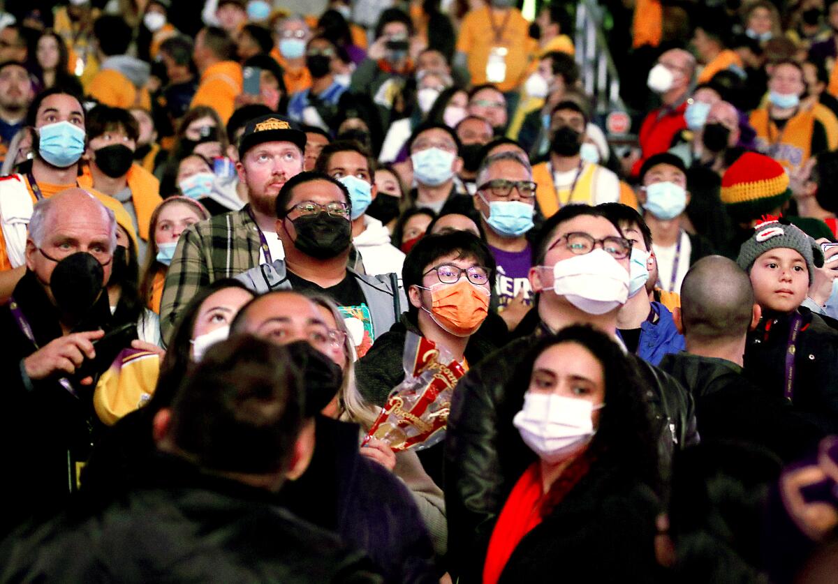 A masked crowd stands together at Staples Center.