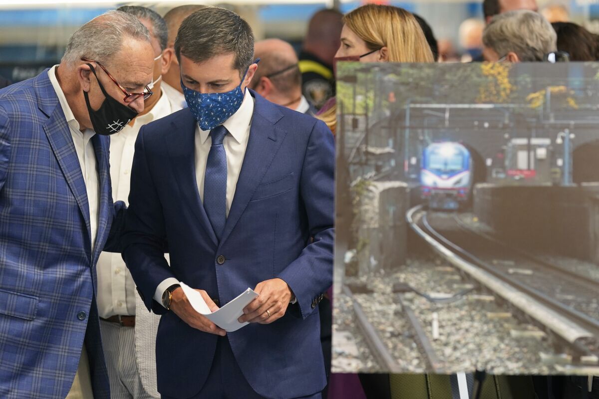 Secretary of Transportation Pete Buttigieg, right, and Sen. Chuck Schumer, D-N.Y., talk before the start of a news conference in New York, Monday, June 28, 2021. Buttigieg toured the century-old rail tunnel connecting New York and New Jersey as a long-delayed project to build a new tunnel gains steam. (AP Photo/Seth Wenig)