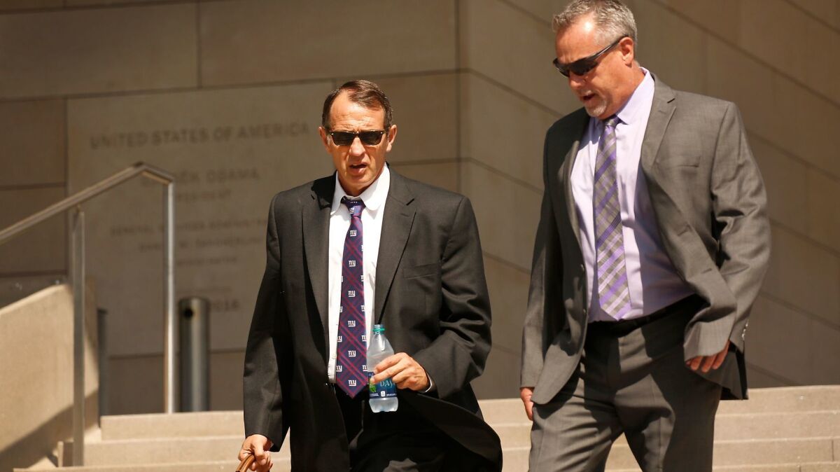 Retired high-ranking Los Angeles County sheriff's Capt. William "Tom" Carey, left, departs the U.S. Federal Courthouse in Los Angeles after his sentencing hearing.