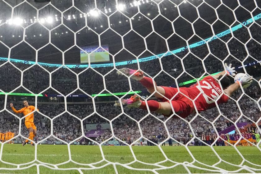 El arquero argentino Emiliano Martínez tapa el disparo de Virgil van Dijk en la tanda de penales en los cuartos de final del Mundial, el viernes 9 de diciembre de 2022, en Lusail, Qatar. (AP Foto/Jorge Saenz)