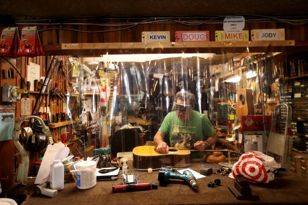 Michael Hawelu, a luthier, repairs guitars at McCabe's Guitar Shop.