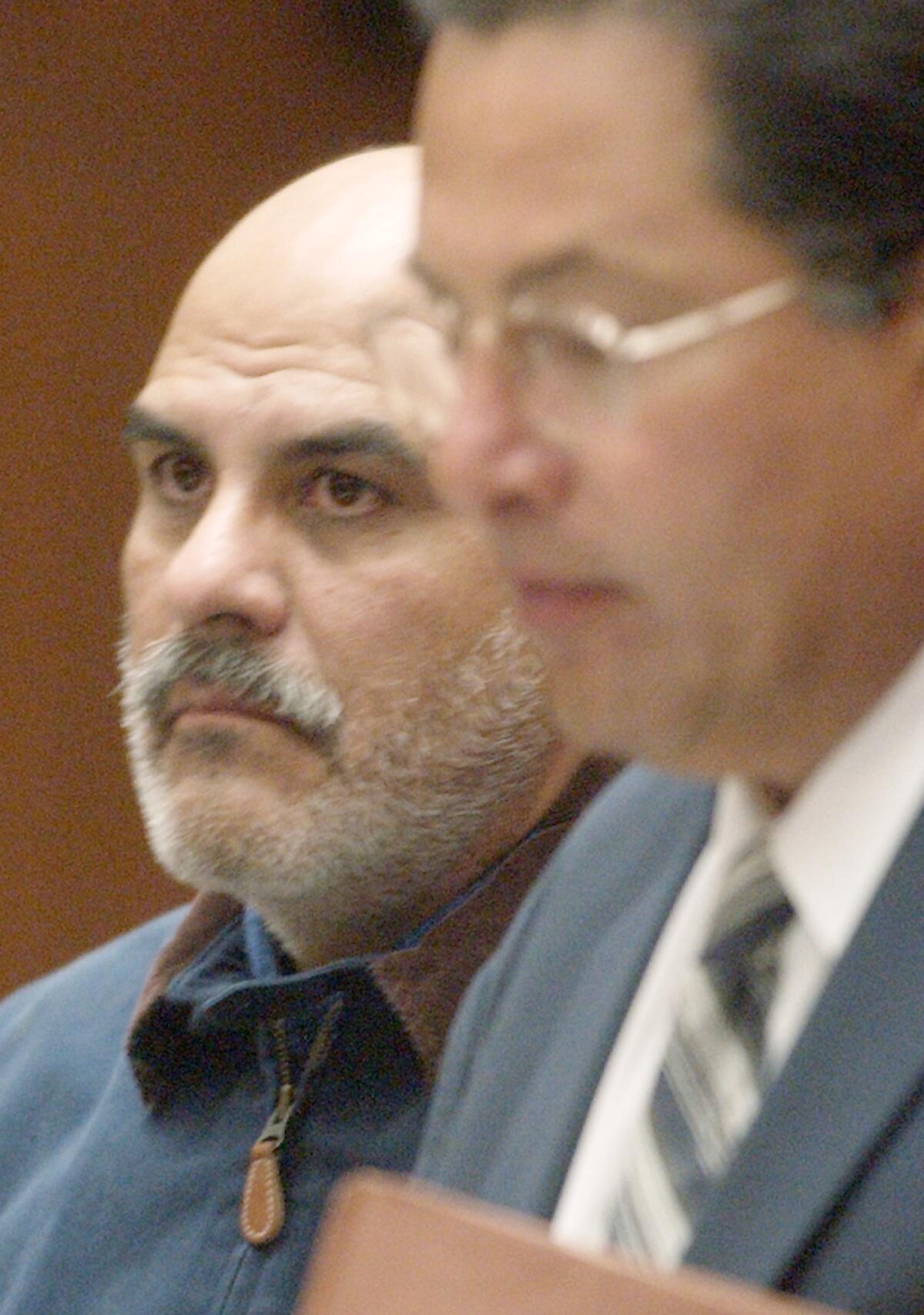 In this file photo, John Anthony Salazar, a former priest accused of sexually assaulting two boys in Los Angeles in the 1980s, appears with his attorney, Daniel Guerrero, right, in Superior Court in Los Angeles for his arraignment in 2003.