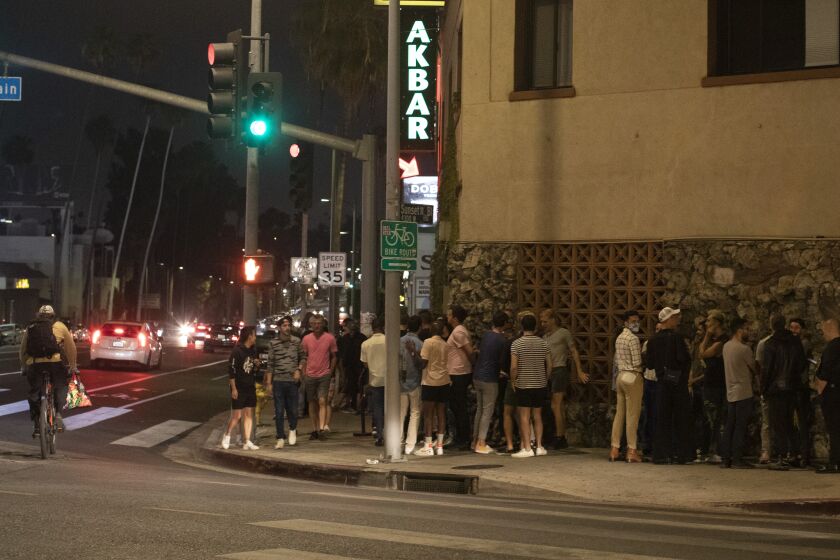LOS ANGELES, CA - JUNE 19: Patrons wait to enter Akbar on Saturday, June 19, 2021 following its reopening. The bar is a longtime fixture of LA's gay disco scene and was in danger of closing, but after a successful fundraiser the club is back in action. (Myung J. Chun / Los Angeles Times)