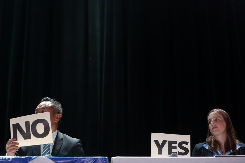 LOS ANGELES, CA-JULY 20, 2019: Council candidates John Lee, left, and Loraine Lundquist, right, respond the audience questions with their yes or no opinion during a Neighborhood Council Town Hall Meeting on July 20, 2019, in Los Angeles, California. The council candidates are representing Granada Hills North and South, Northridge East and West and Porter Ranch. (Photo By Dania Maxwell / Los Angeles Times)
