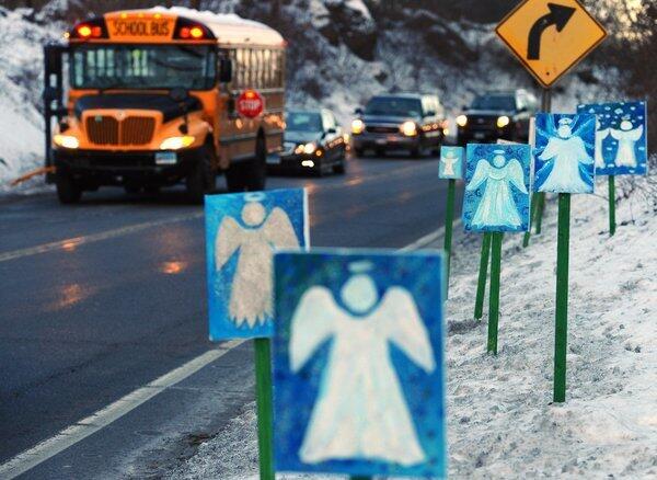 A school bus stops in front of 26 angels on the first day of classes since the shooting for Sandy Hook students.