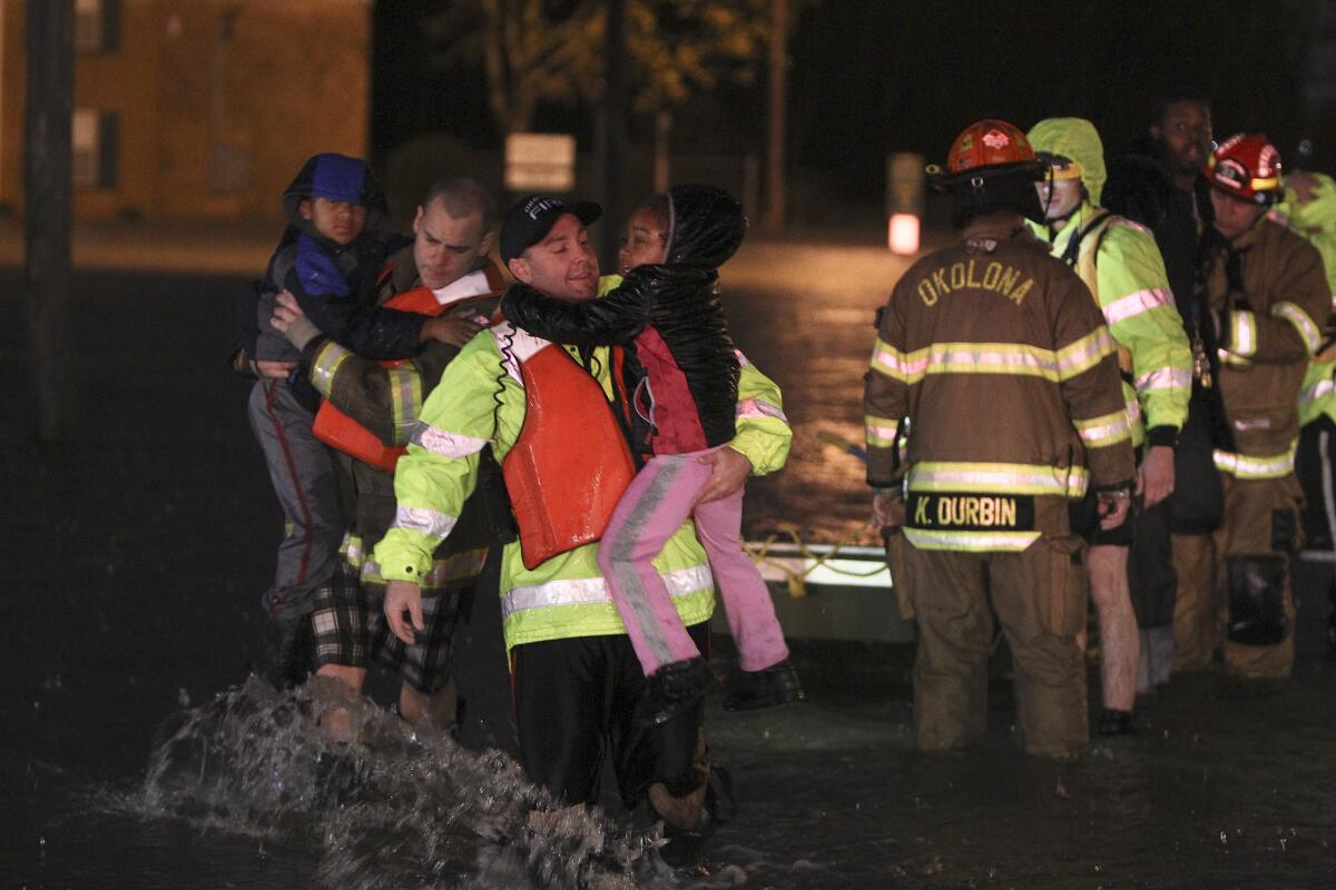 Rescue crews help residents at the Guardian Court Apartments evacuate after flooding in the area on Friday, April 3, 2015, in Louisville, Ky.