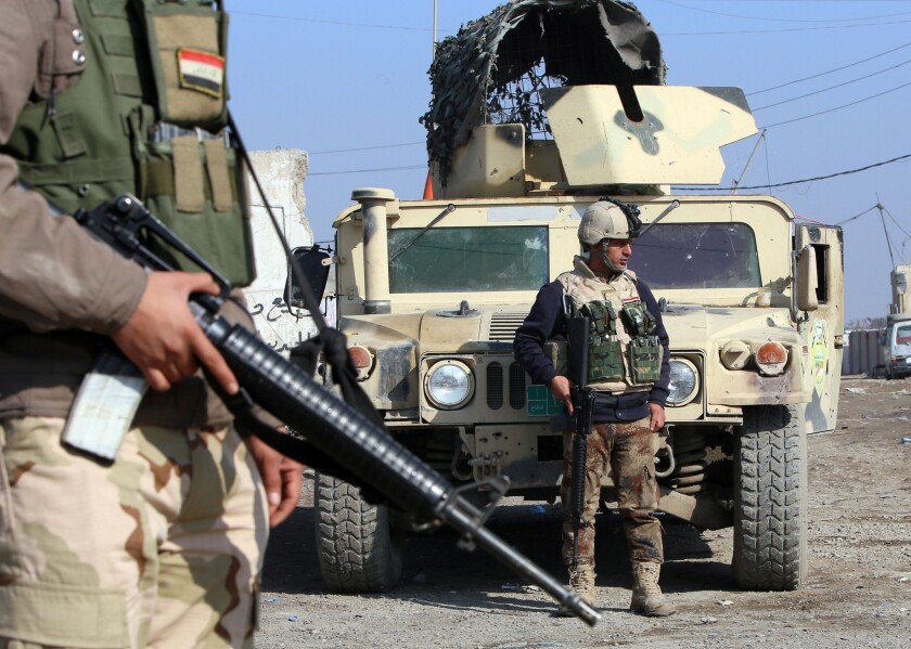 Iraqi soldiers monitor a checkpoint east of Baghdad on Monday. Prime Minister Nouri Maliki has warned of an impending offensive to drive out Al Qaeda-aligned militants who have seized Fallouja and other Sunni strongholds in Anbar province.