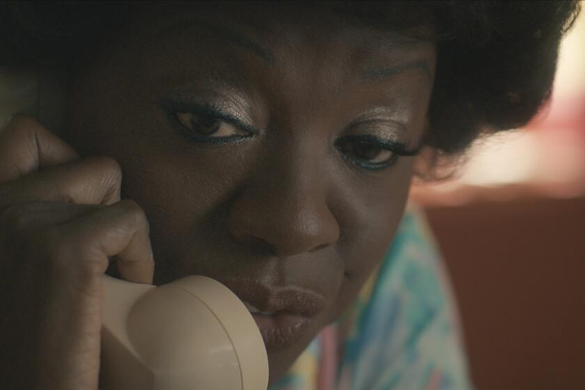 A close-up shot of a woman holding a landline phone to her ear