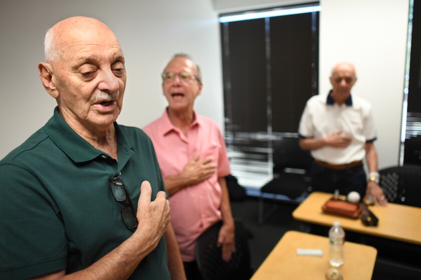 Al Hassan sings along during the national anthem at the start of BasebALZ's July meeting.