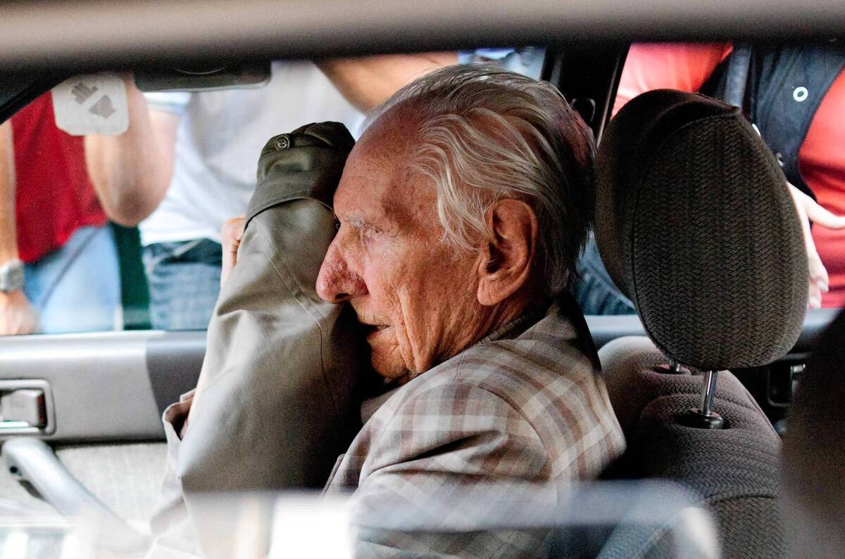Alleged Hungarian war criminal Laszlo Csatary covers his face in a car as he leaves the Budapest prosecutor's office in 2012, where he was questioned by detectives on charges of war crimes. He was indicted in June 2013 by Hungarian authorities for abusing Jews and contributing to their deportation to Nazi death camps during World War II.
