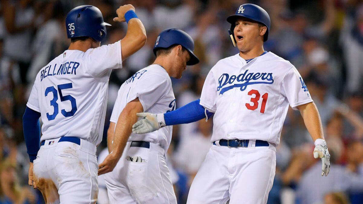 Dodgers' Joc Pederson, right, celebrates his three-run home run with Cody Bellinger, left, and Logan Forsythe during the sixth inning the Angels on Tuesday.