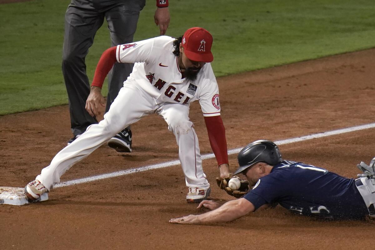 The ball comes out of the glove of Angels third baseman Anthony Rendon as Seattle Mariners' Kyle Seager slides.