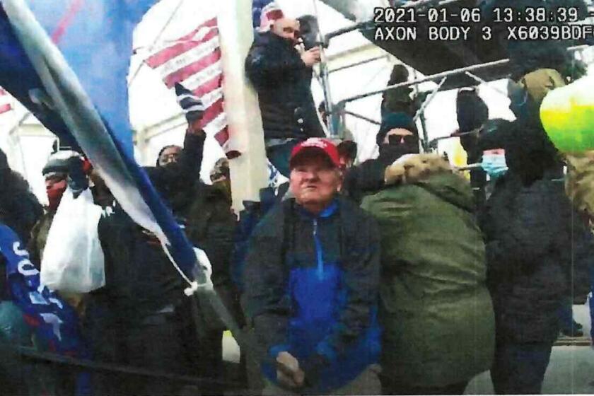 This image from police-worn body cam video and contained in the statement of facts supporting the arrest warrant for Howard Richardson, shows Richardson swinging a metal flagpole on Jan. 6, 2021, at the U.S. Capitol in Washington. Richardson was sentenced Aug. 26, 2022, to 46 months in federal prison for attacking a police officer with a Trump flag during the Capitol riot, The Philadelphia Inquirer reported. (Department of Justice via AP)