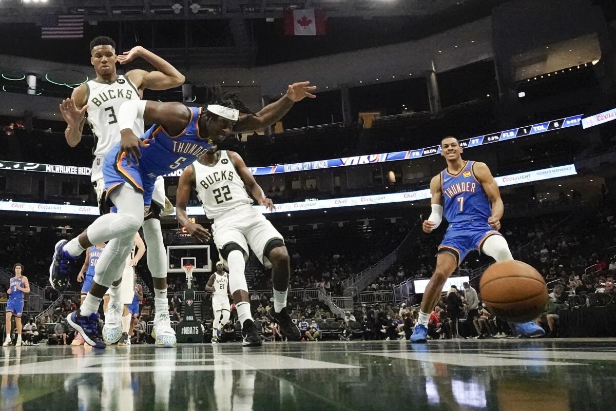 Oklahoma City Thunder's Luguentz Dort and Milwaukee Bucks' Giannis Antetokounmpo go after a loose ball during the first half of an NBA preseason basketball game Sunday, Oct. 10, 2021, in Milwaukee. (AP Photo/Morry Gash)