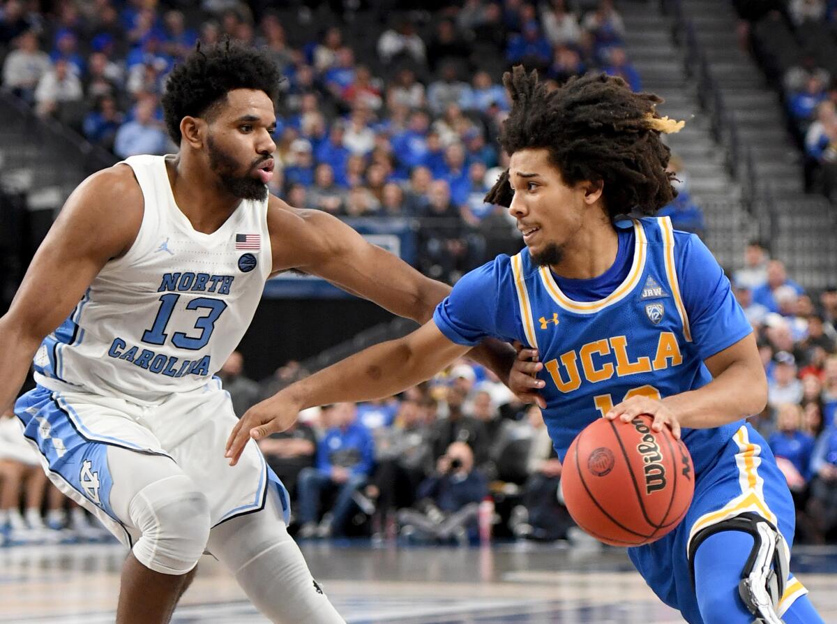 UCLA's Tyger Campbell drives against North Carolina's Jeremiah Francis on Dec. 21 at T-Mobile Arena in Las Vegas. 