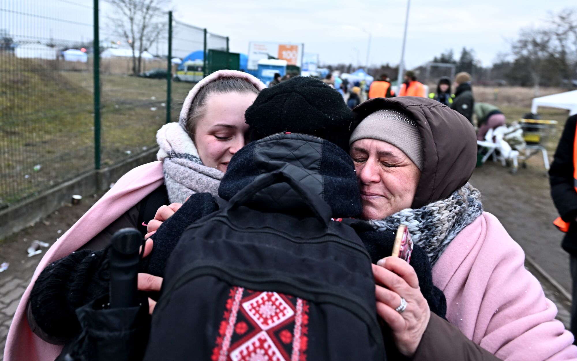 Ukrainian refugee Orest Hromnadzkiy gets a hug from his sister Yuliia and mother Alla after he crossed the border in Poland.