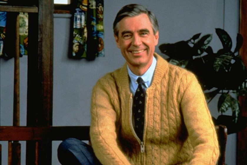 ** FILE ** Fred Rogers poses on the Pittsburgh set of his television show Mister Rogers' Neighborhood, in this 1996 publicity photo. Fred Rogers, who gently invited millions of children to be his neighbor as host of the public television show Mister Rogers Neighborhood for more than 30 years, died of cancer early Thursday, February 27, 2003. He was 74. (AP Photo/pool) ORG XMIT: NY122